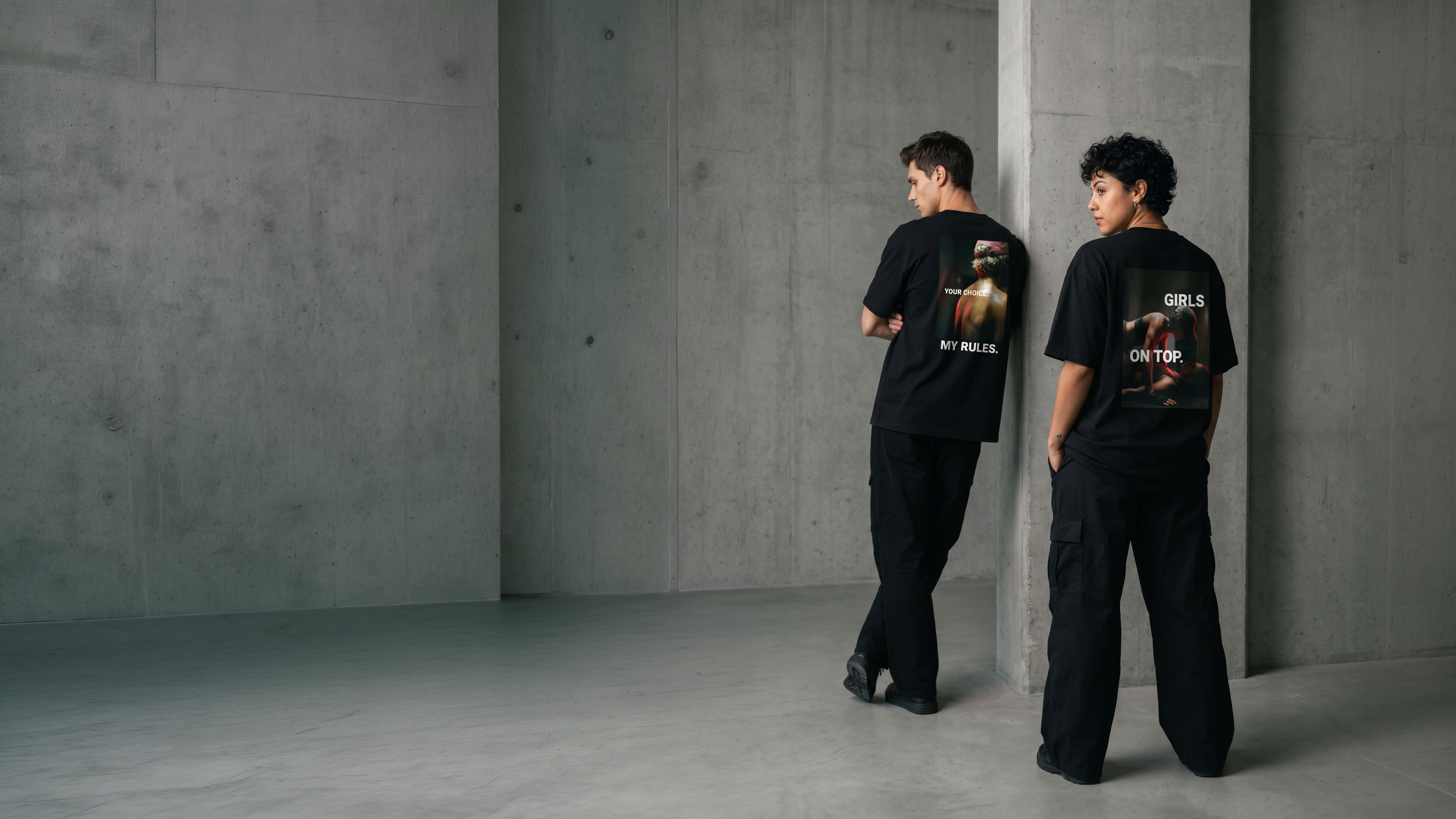 Zwei Models von hinten in Betonkulisse, tragen schwarze Oversized Shirts mit Backprint ‚Your Choice My Rules' und ‚Girls On Top' – neue Statement-Kollektion von The Ritual.